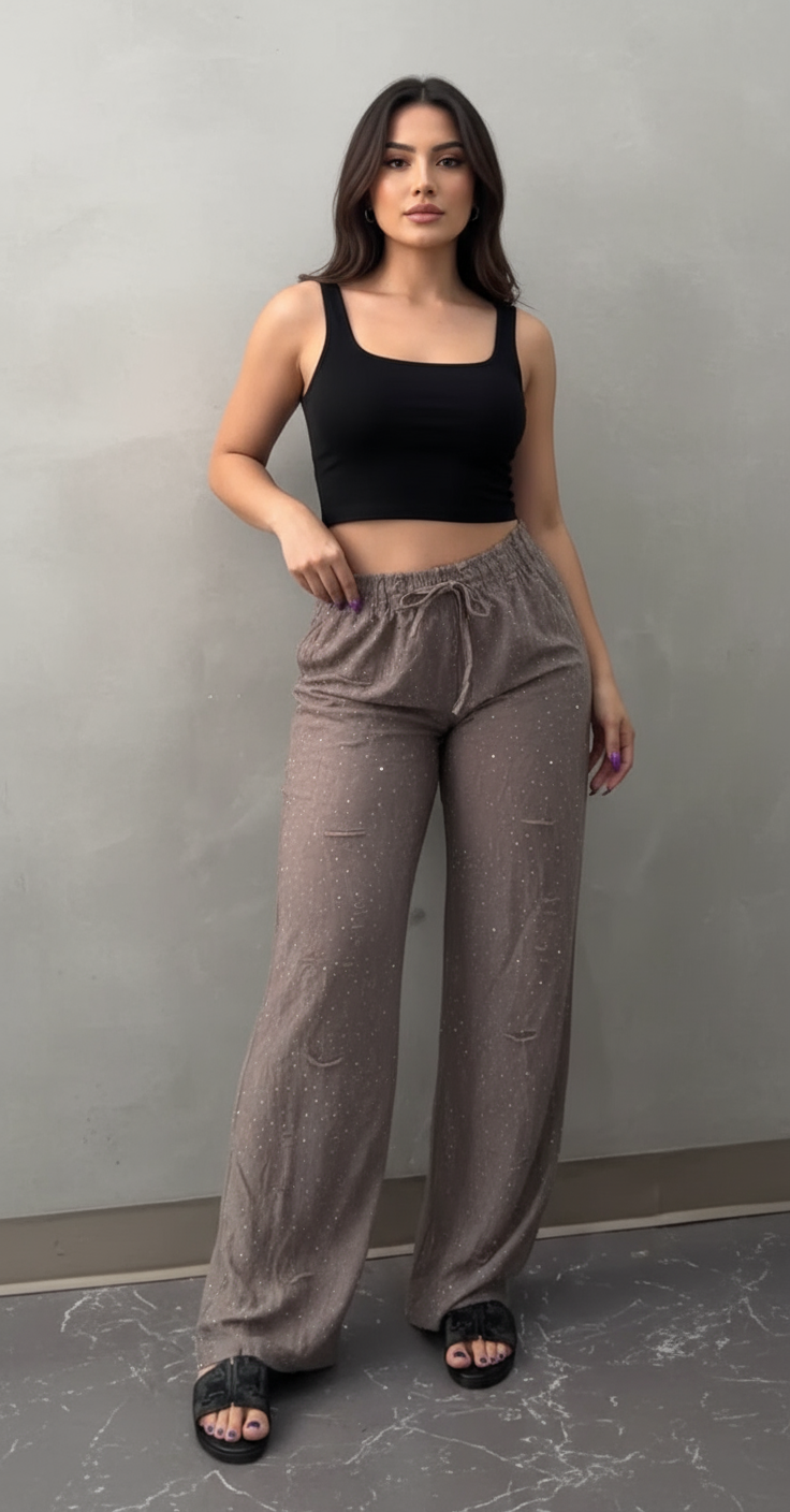 Modelo con cara visible luciendo pantalones grises brillantes